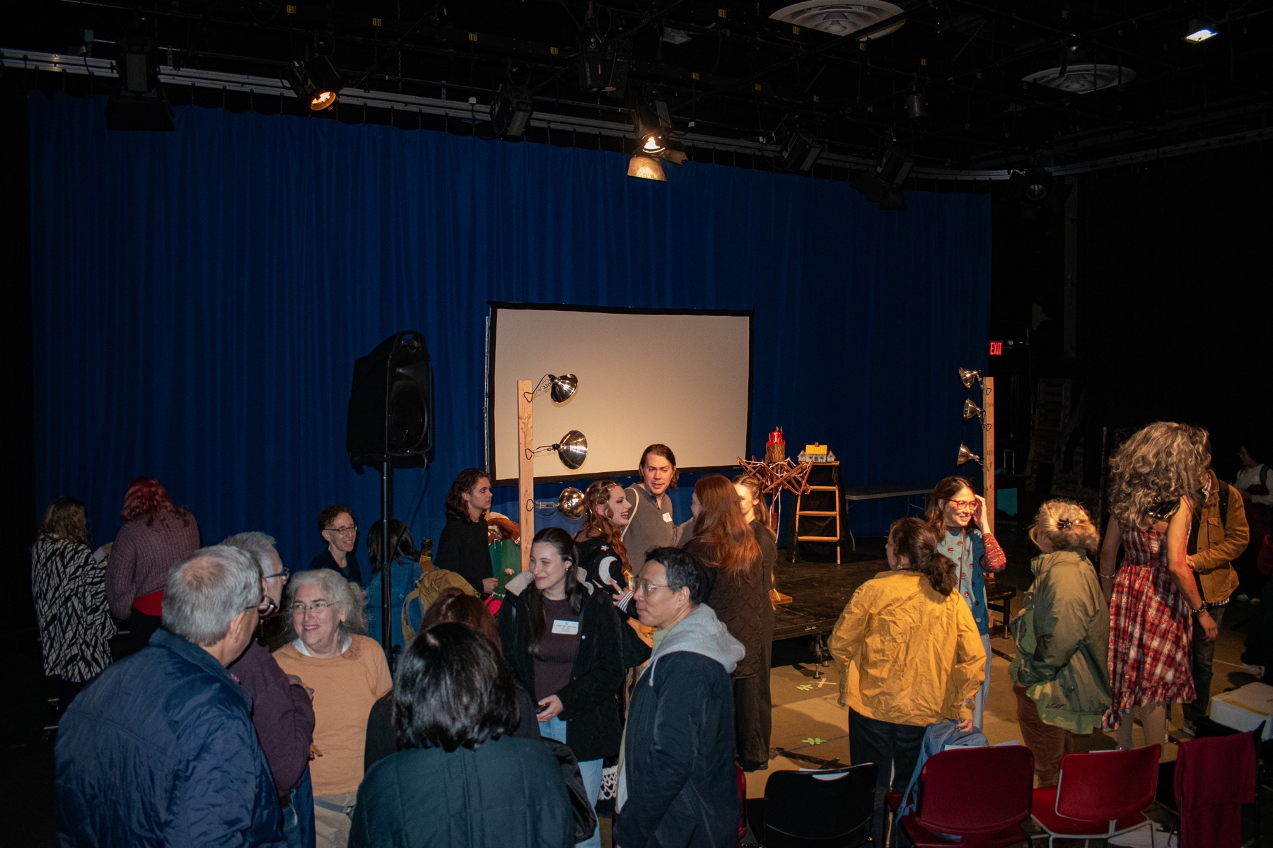 Performers and audience members gathering in a theatre after a show